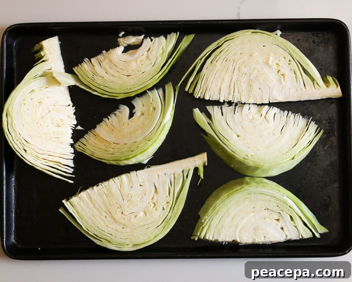 Raw cabbage wedges on baking sheet.