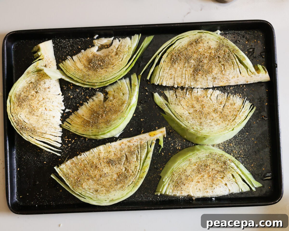 Seasoned cabbage wedges on a baking tray.