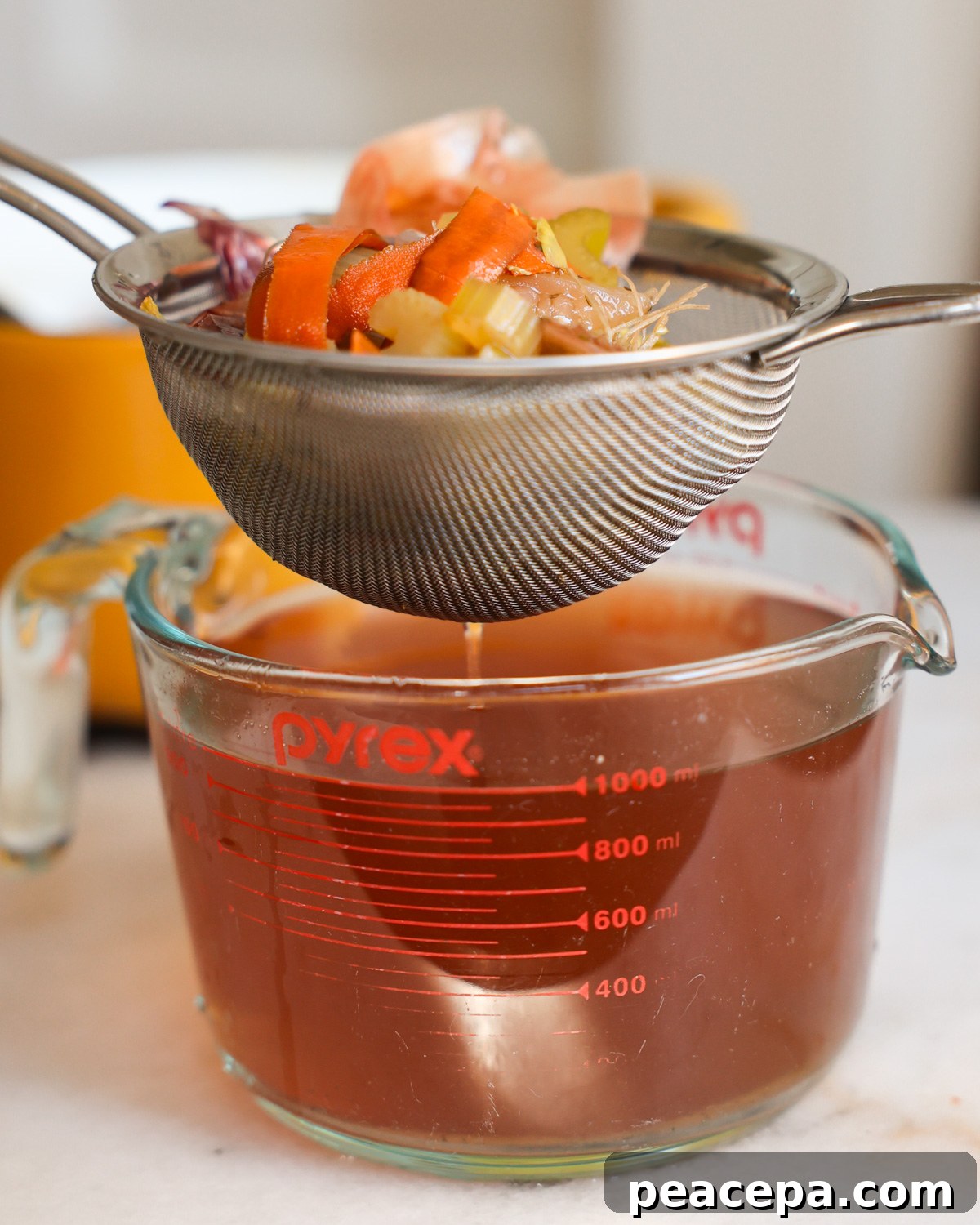 straining vegetable broth