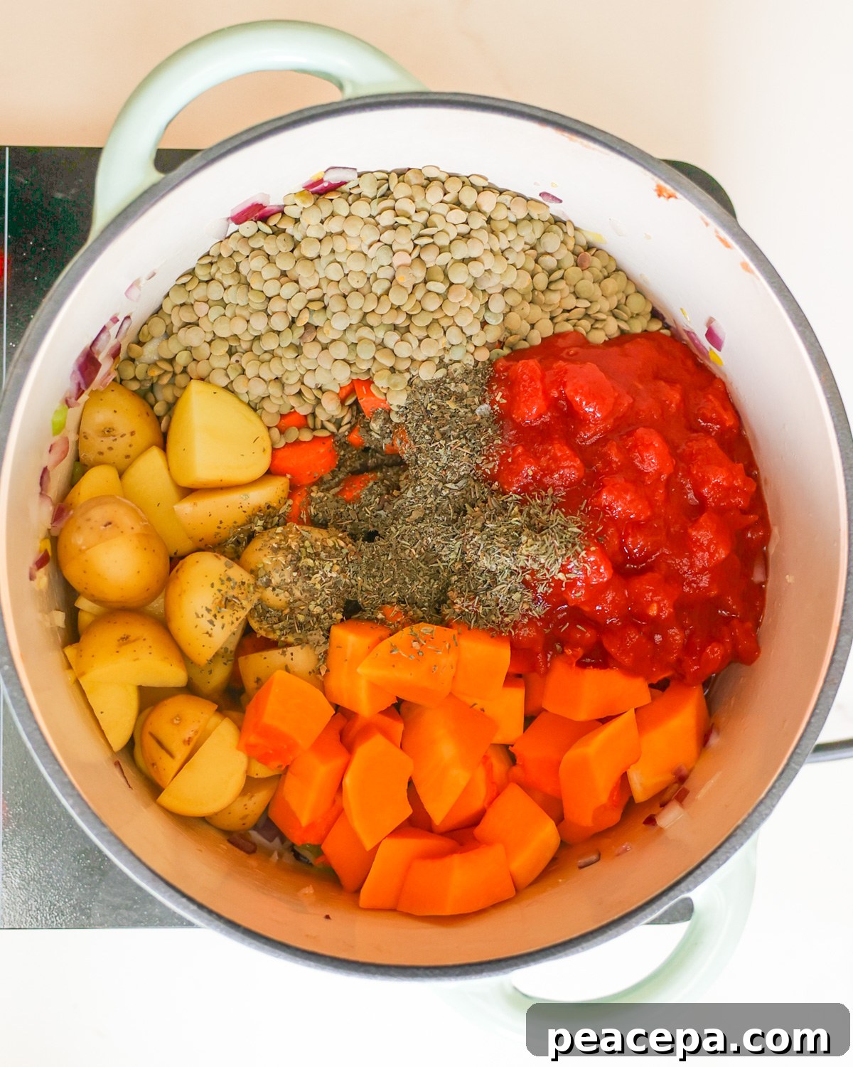 An overhead shot of a pot of the butternut squash and lentil soup ingredients before adding the broth.