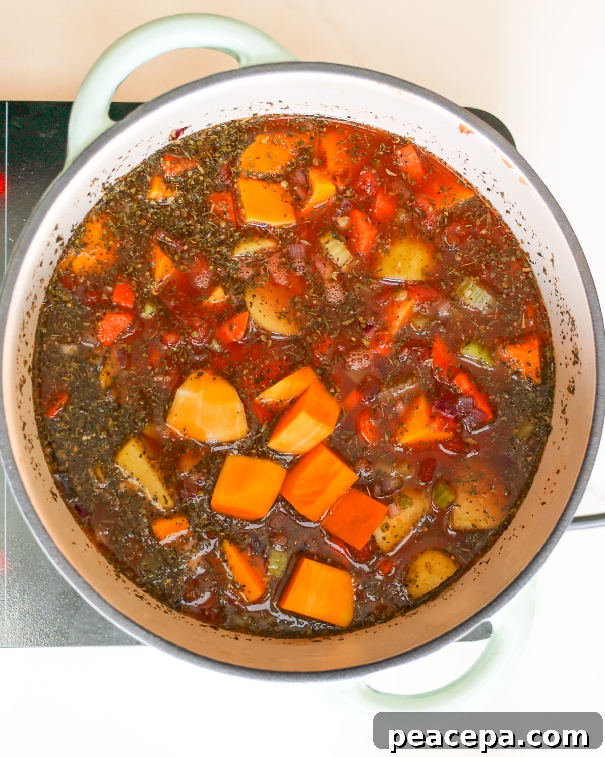 An overhead shot of the pot of butternut squash lentil soup before it comes to a boil.