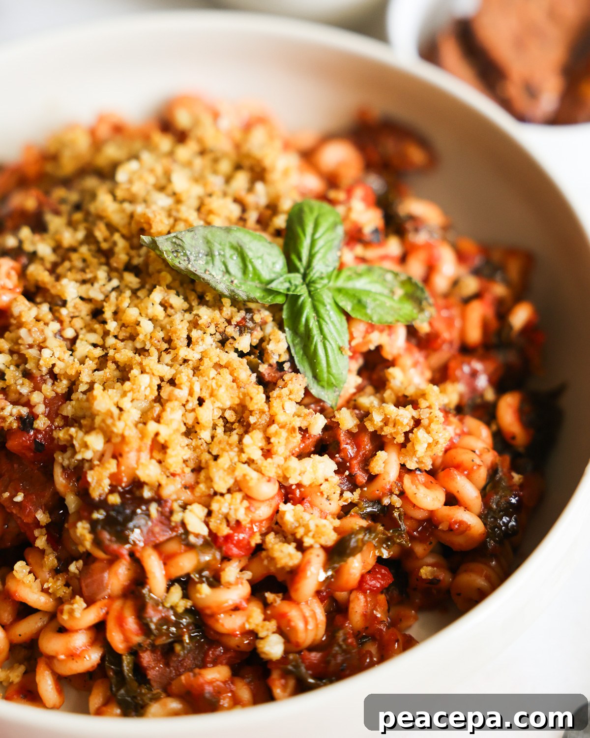 A closeup shot of a white bowl of Instant Pot Vegan Sausage Pasta.