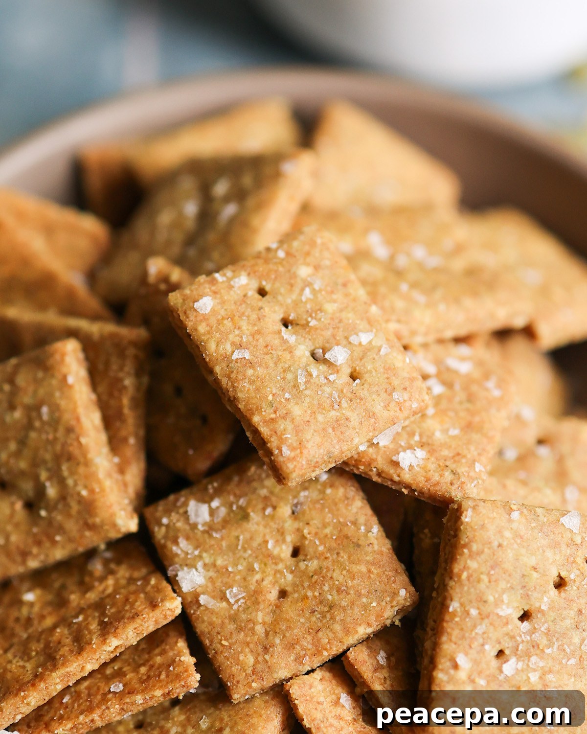 An up-close shot of "cheesy" pumpkin seed crackers in a bowl.