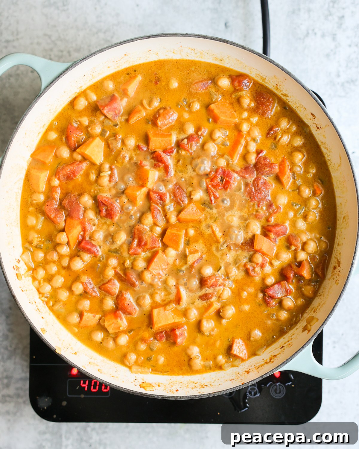 Chickpea curry simmering in skillet.