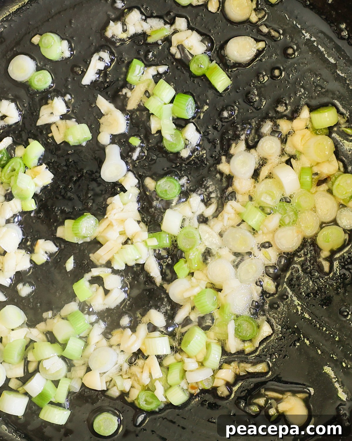 close up sautéeing garlic and scallions
