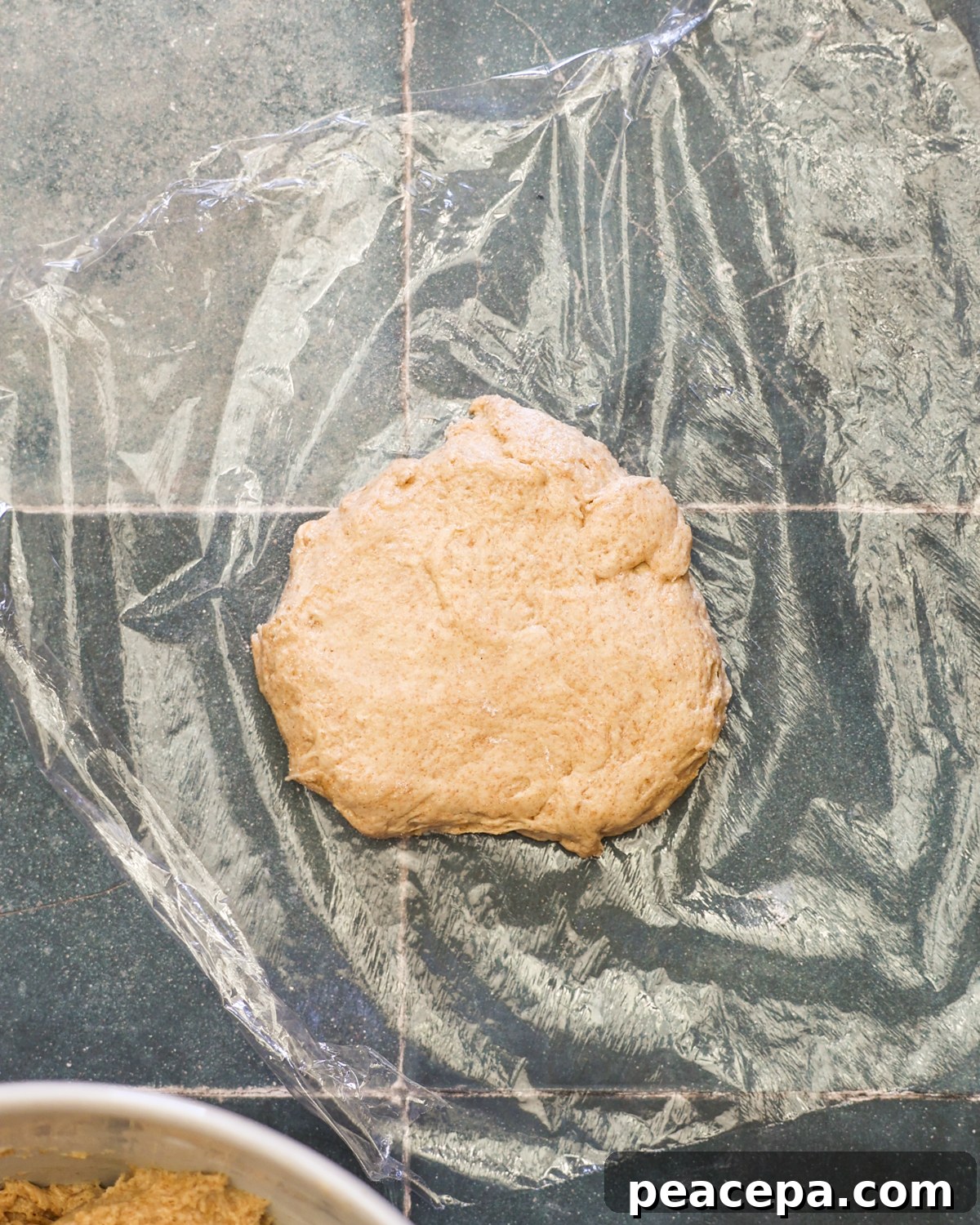 overhead wrapping dough with plastic wrap