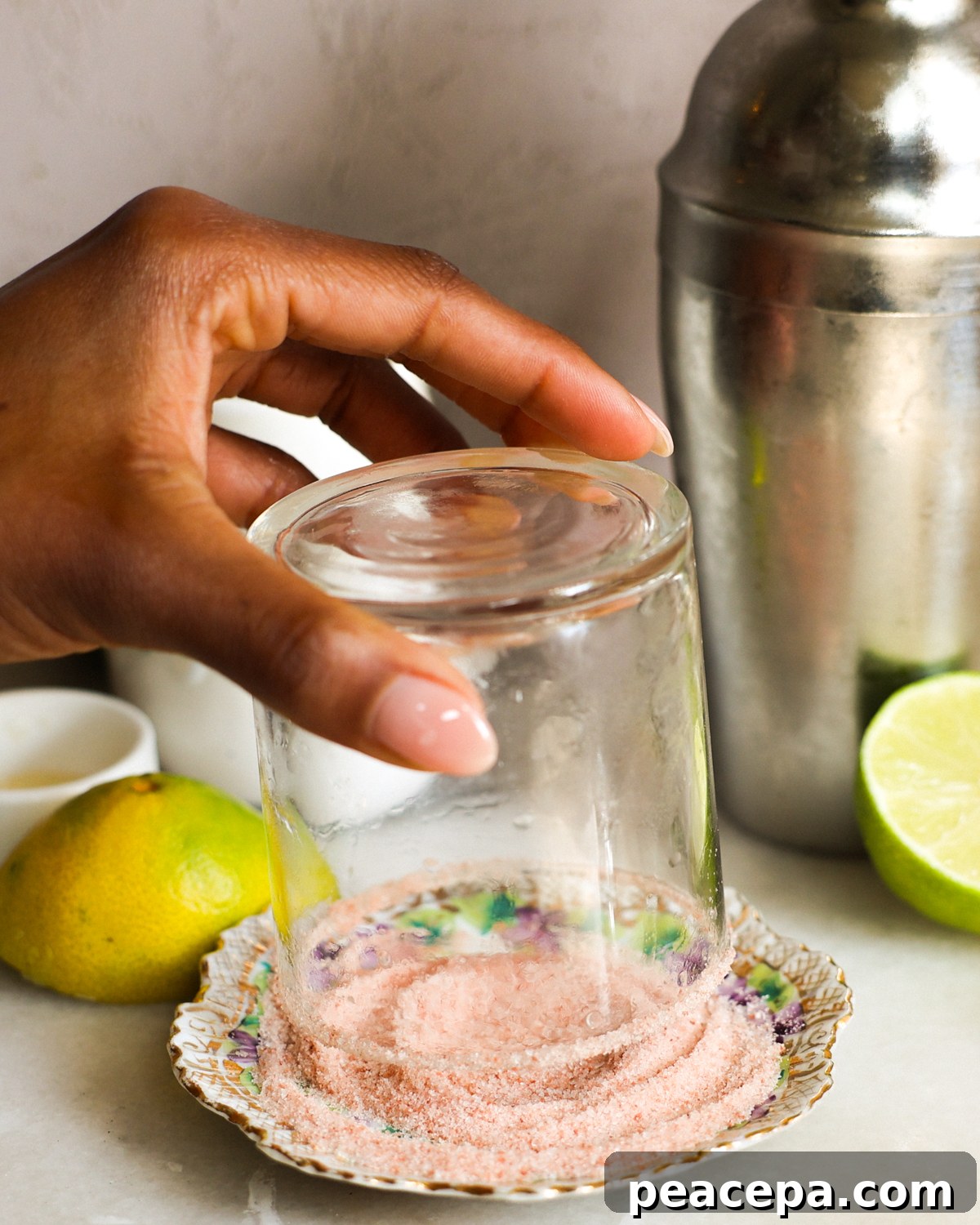 Rimming a cocktail glass with salt.