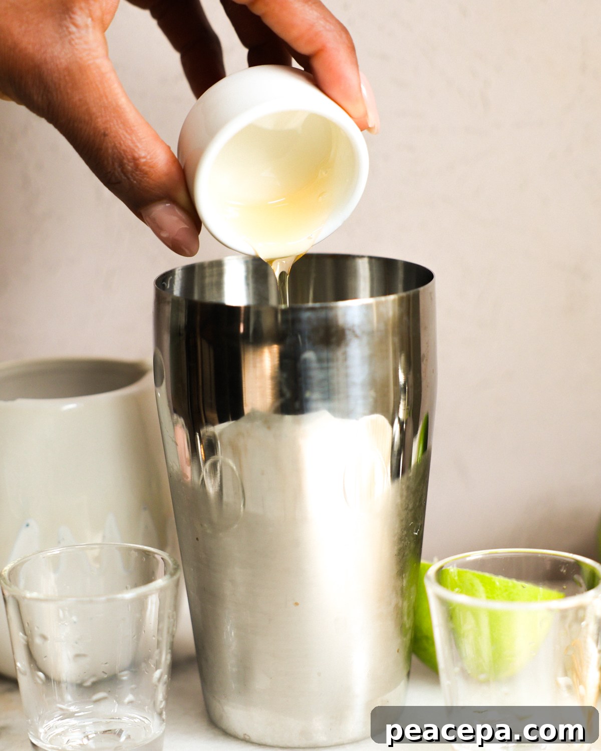 Adding margarita ingredients to cocktail shaker.