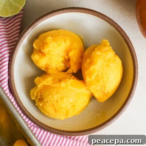 overhead of mango sorbet scoops in a bowl