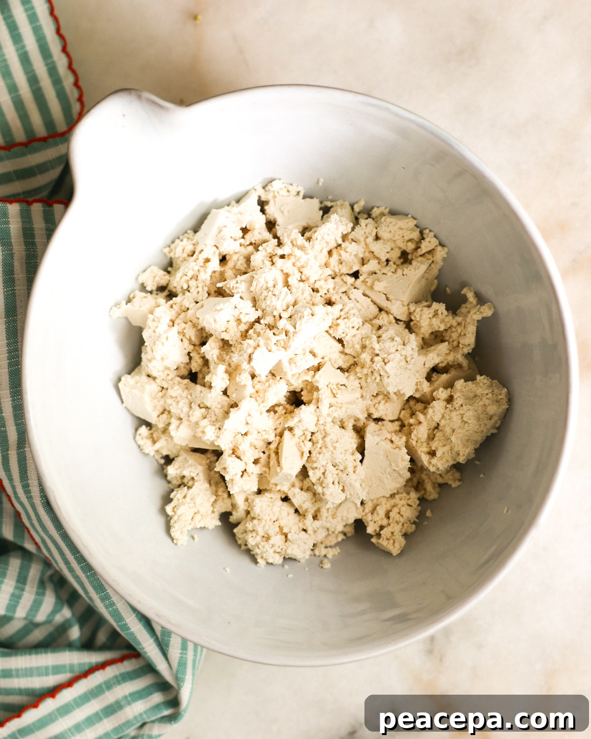 overhead of crumbled tofu in a mixing bowl