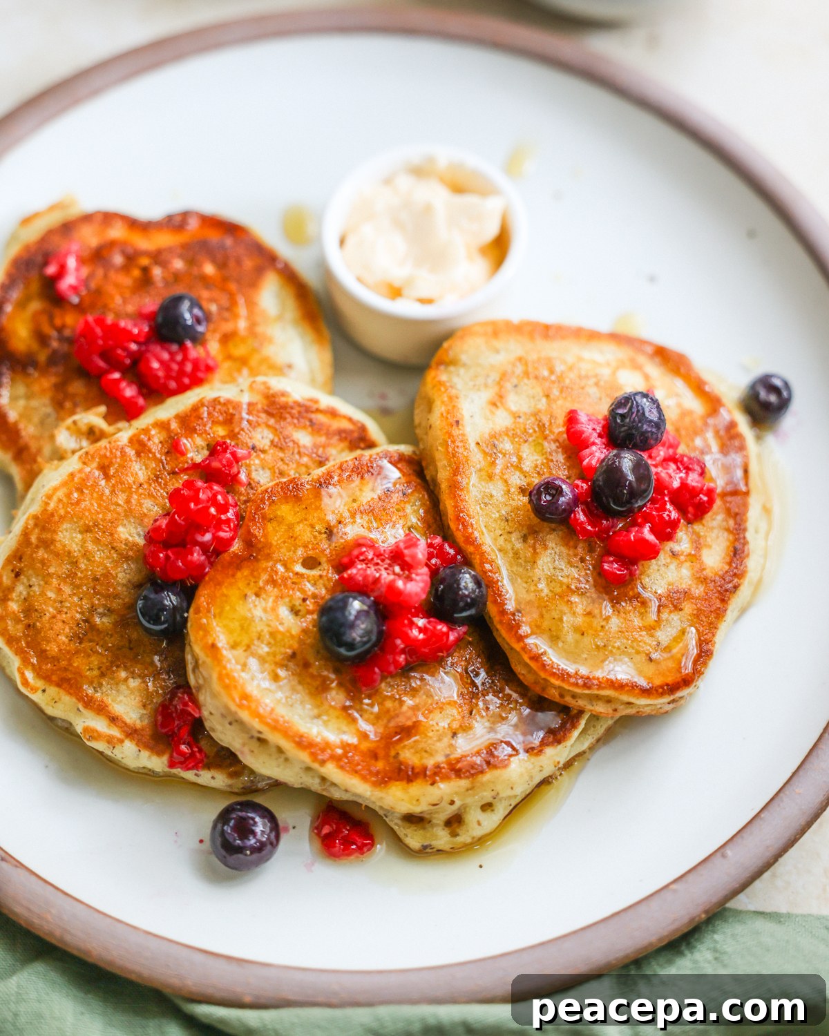 An overhead shot of a plate of sourdough discard pancakes with berries.