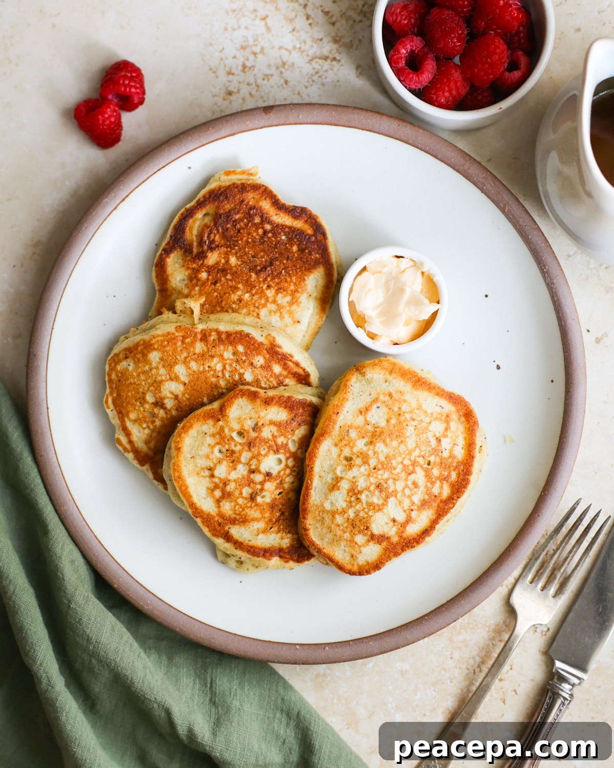 An overhead shot of a plate of sourdough discard pancakes with a small dish of vegan butter.