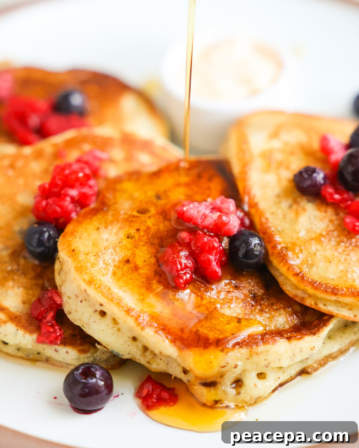 A close-up shot of the sourdough discard pancakes with maple syrup.