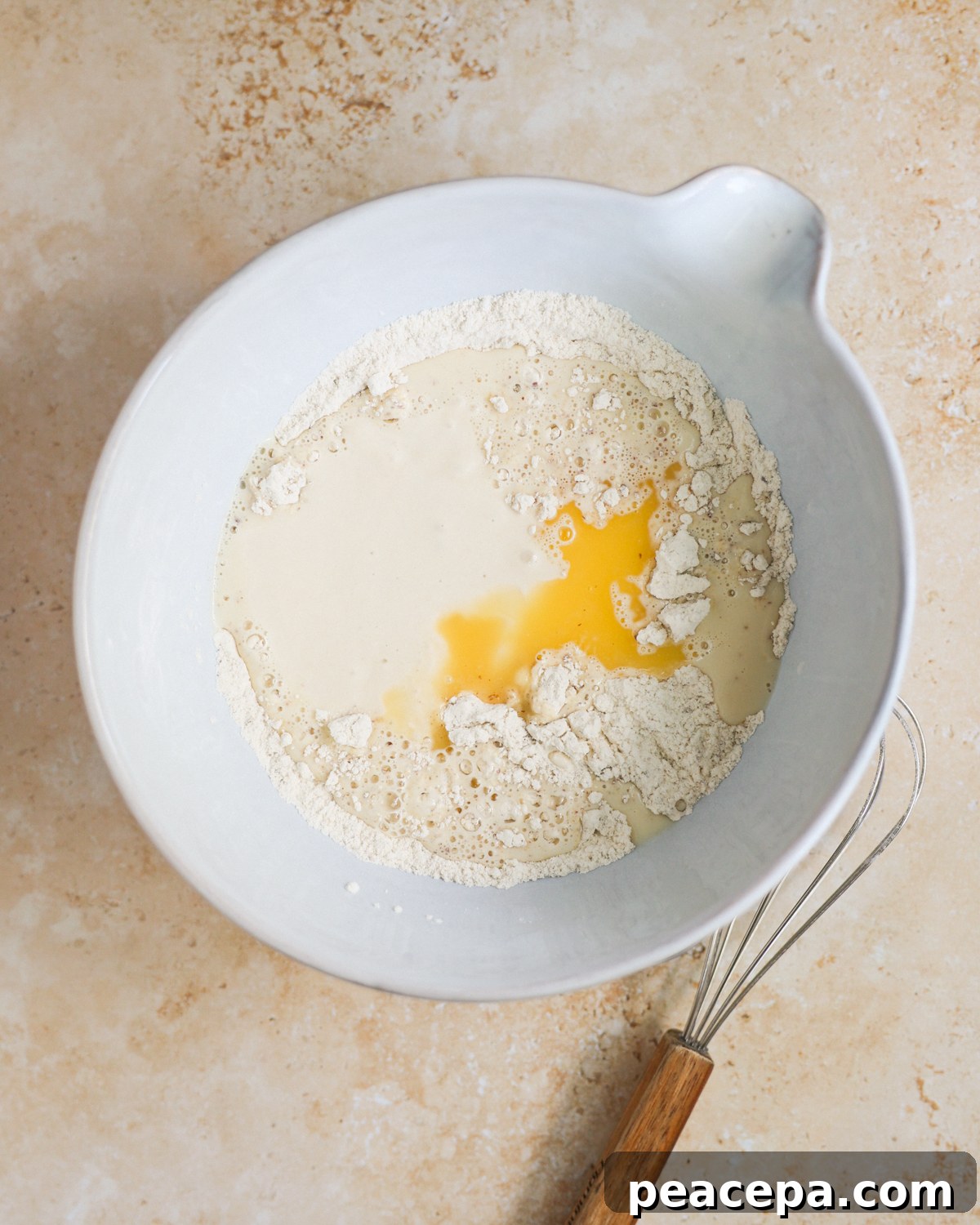 A mixing bowl with the sourdough discard, flour, melted butter, and other pancake ingredients.