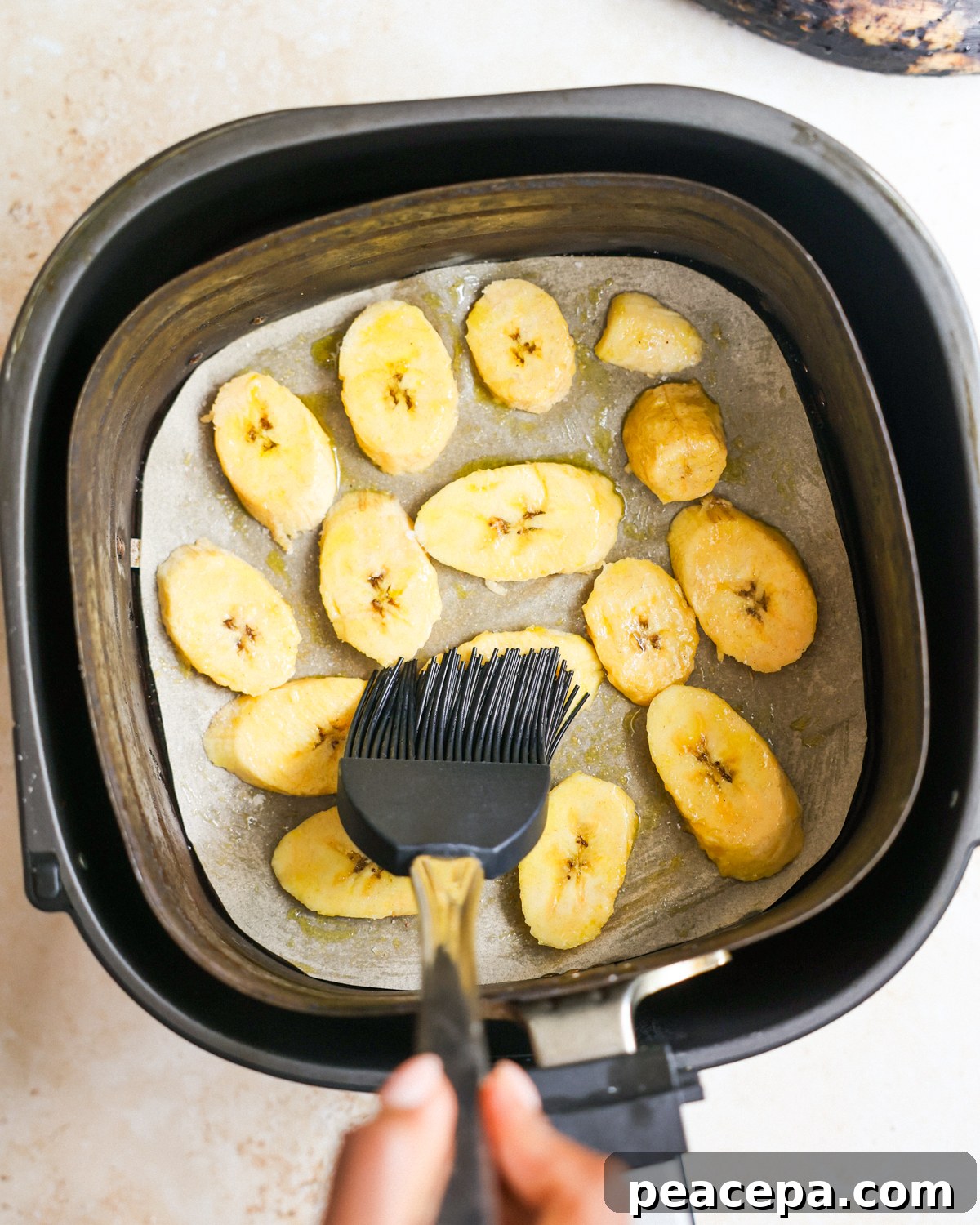 brushing oil on plantains