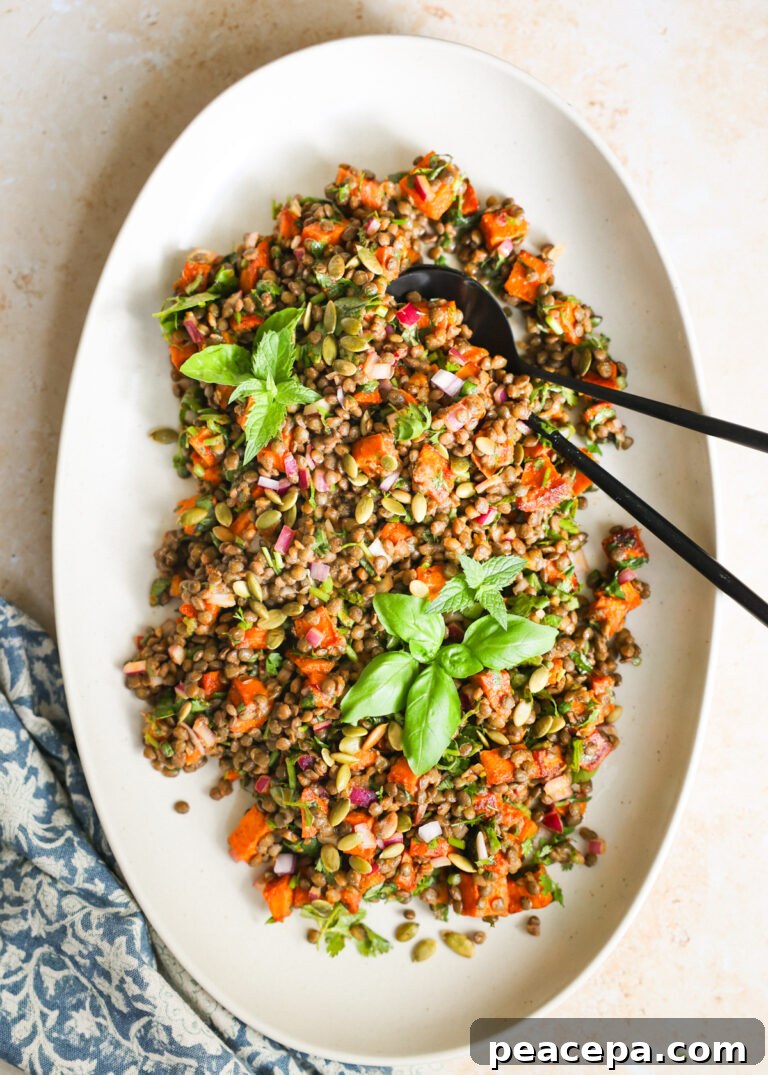Lovely Lentil Salad on a large serving platter with serving utensils.