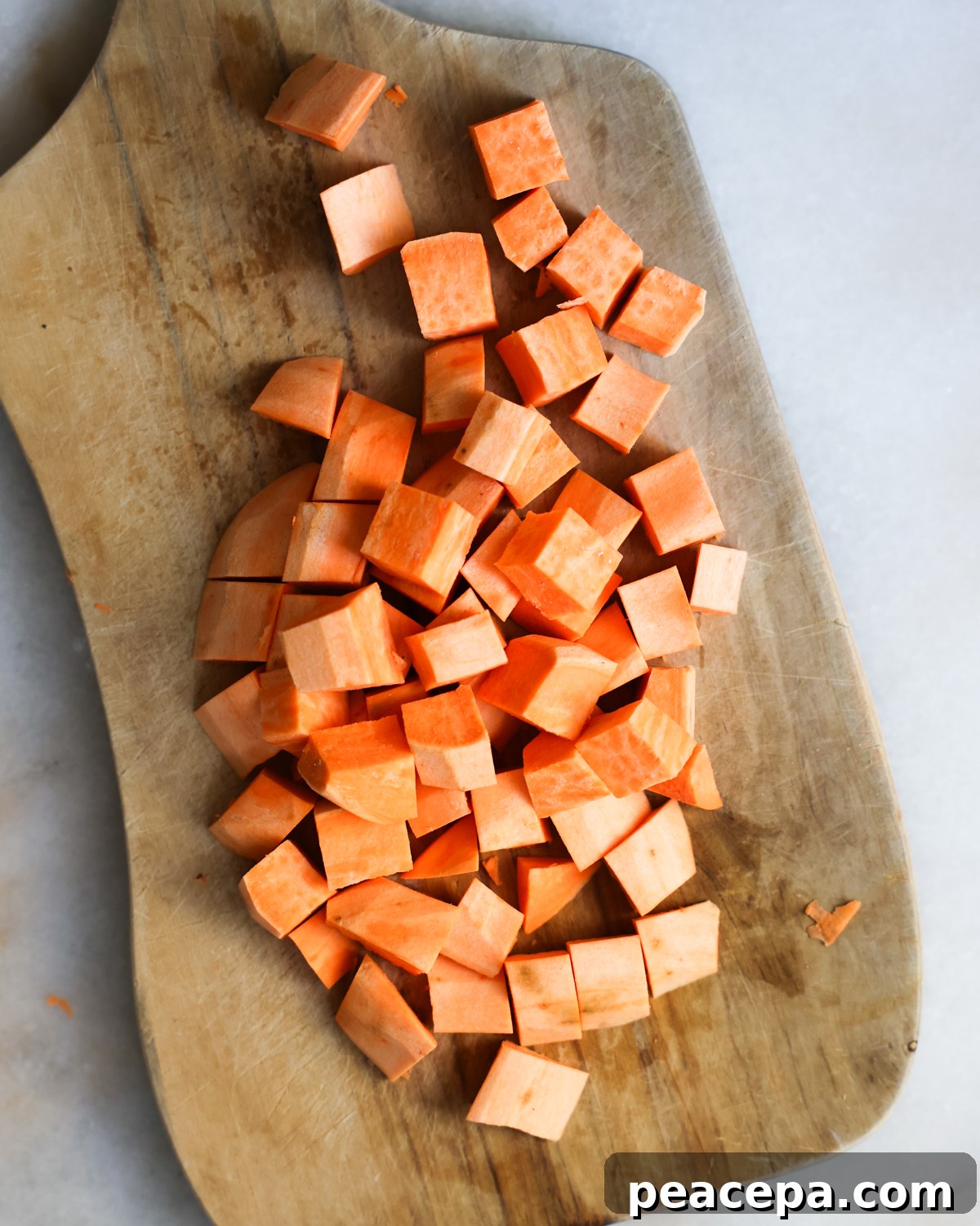 Cubed sweet potatoes on cutting board.