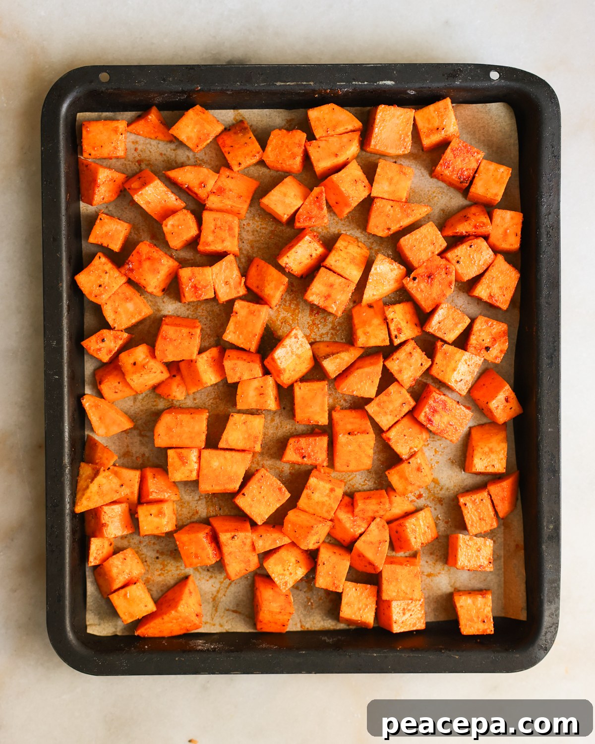Sweet potatoes spread on baking sheet.