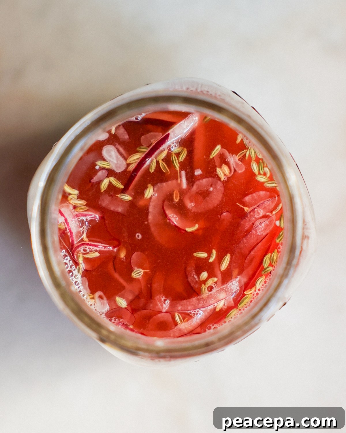 overhead of onions in jar with pickling liquid