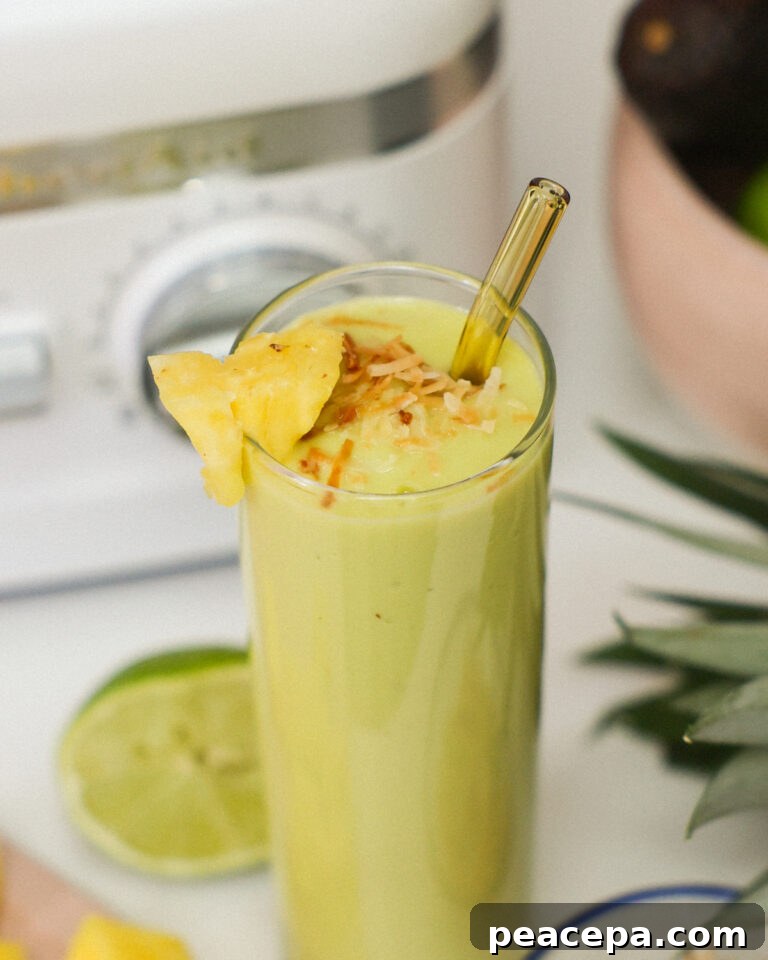 Energizing Avocado Smoothie in a glass with a straw.