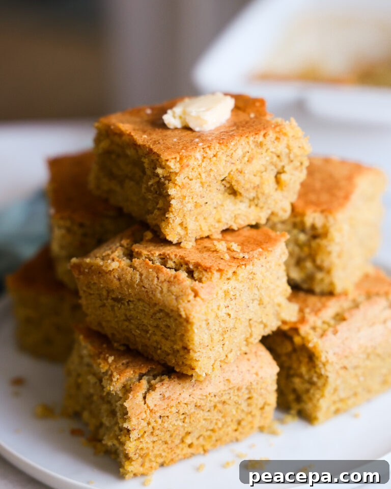 Pieces of Vegan Gluten-Free Cornbread stacked on a plate with butter on top.