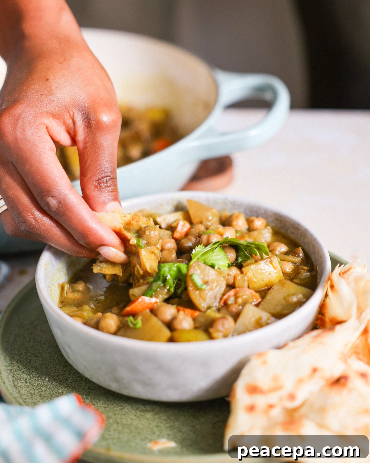 Dipping roti in jamaican curry