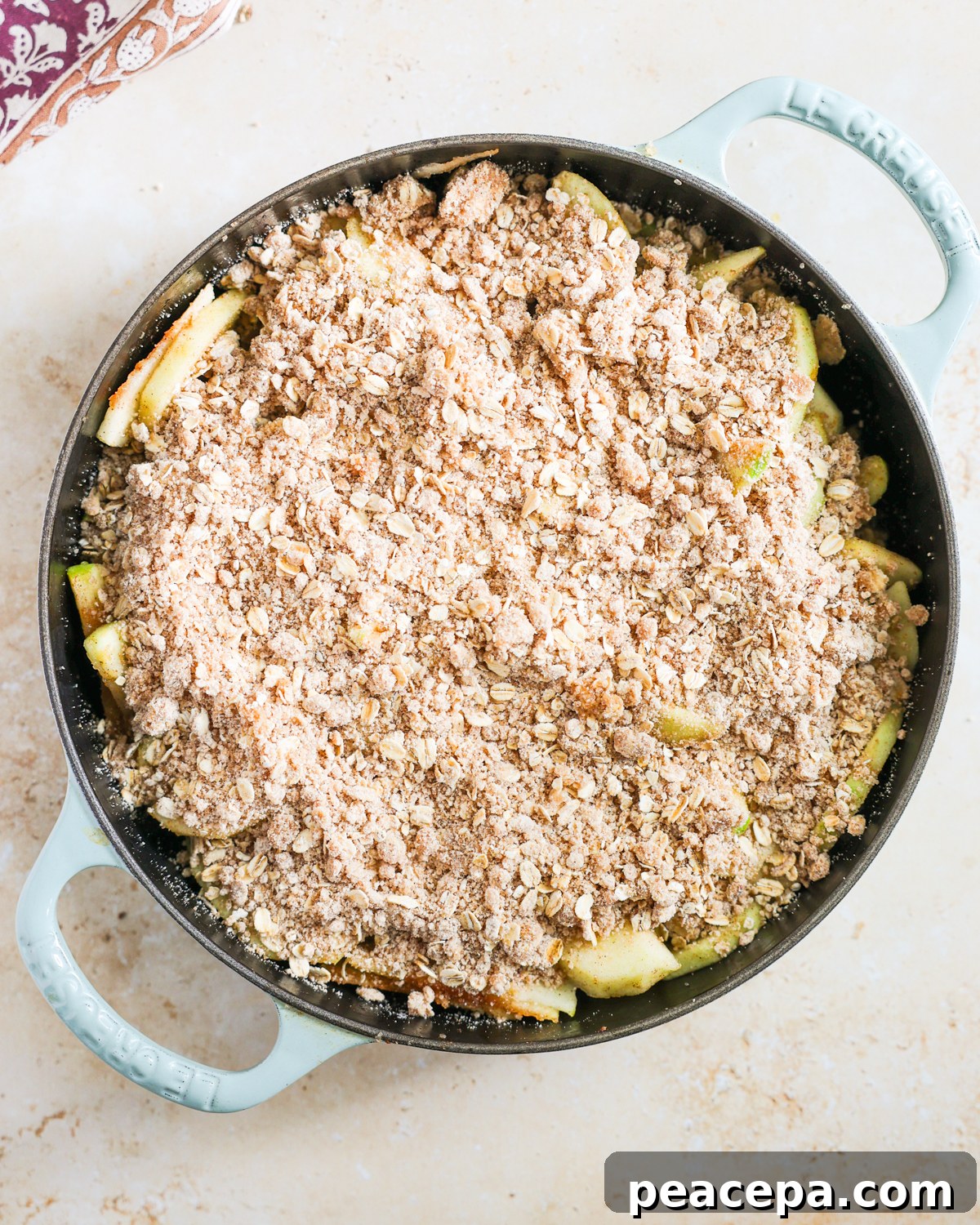 Apples topped with crumble topping in skillet. 