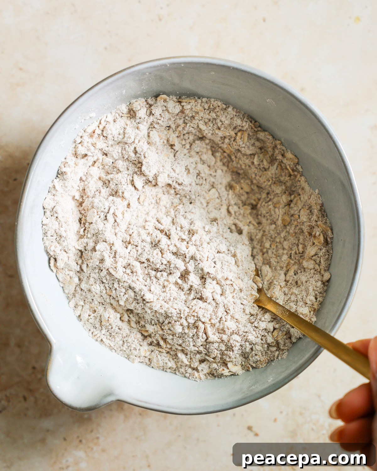 Stirring the oat topping in a bowl. 
