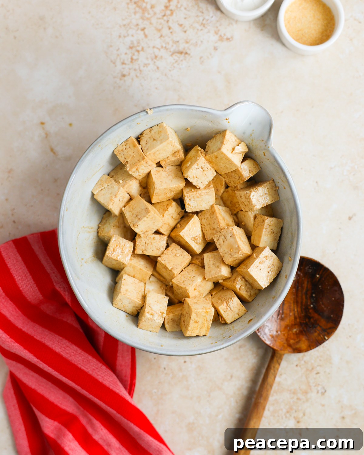 Tofu in bowl tossed with soy sauce.