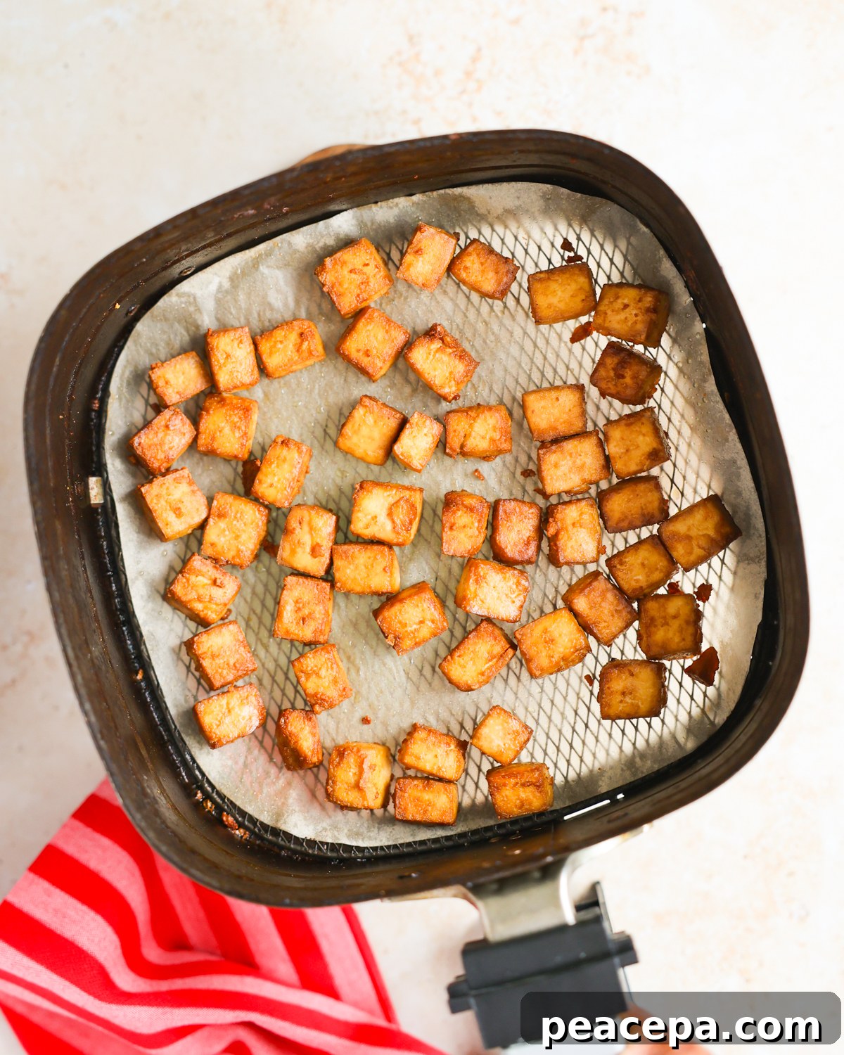 Air fried tofu in air fryer basket.