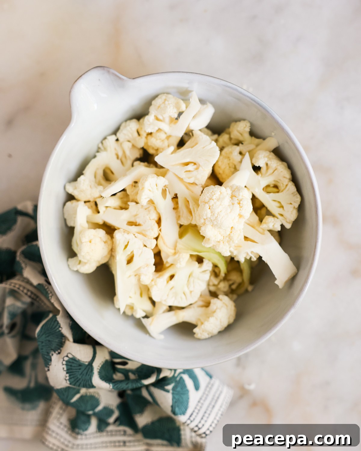 overhead of chopped cauliflower in a mixing bowl