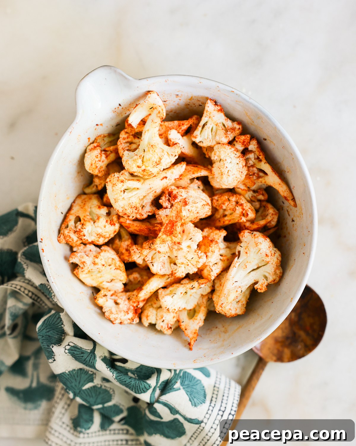 seasoned cauliflower in mixing bowl