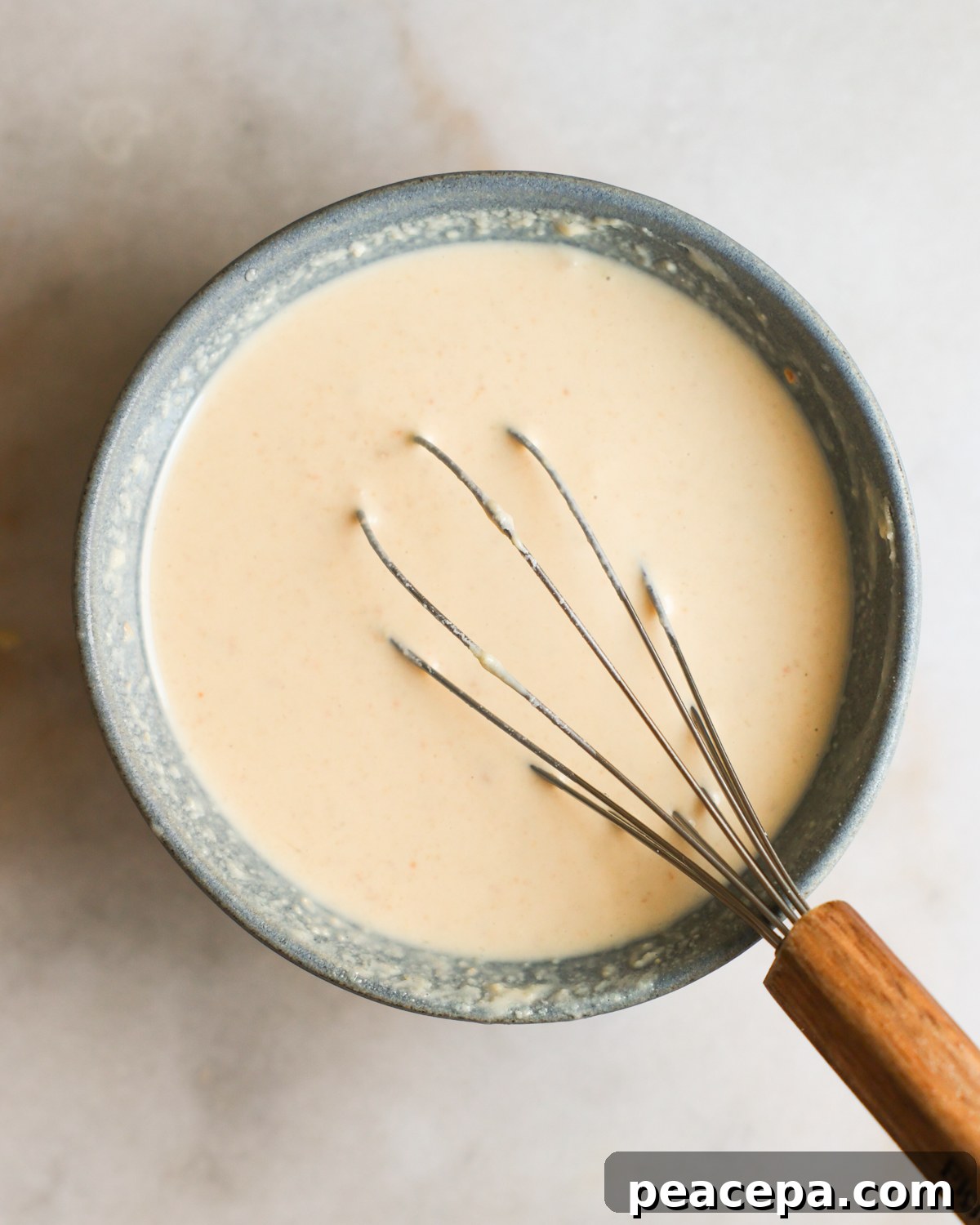overhead of whisking creamy tahini dressing