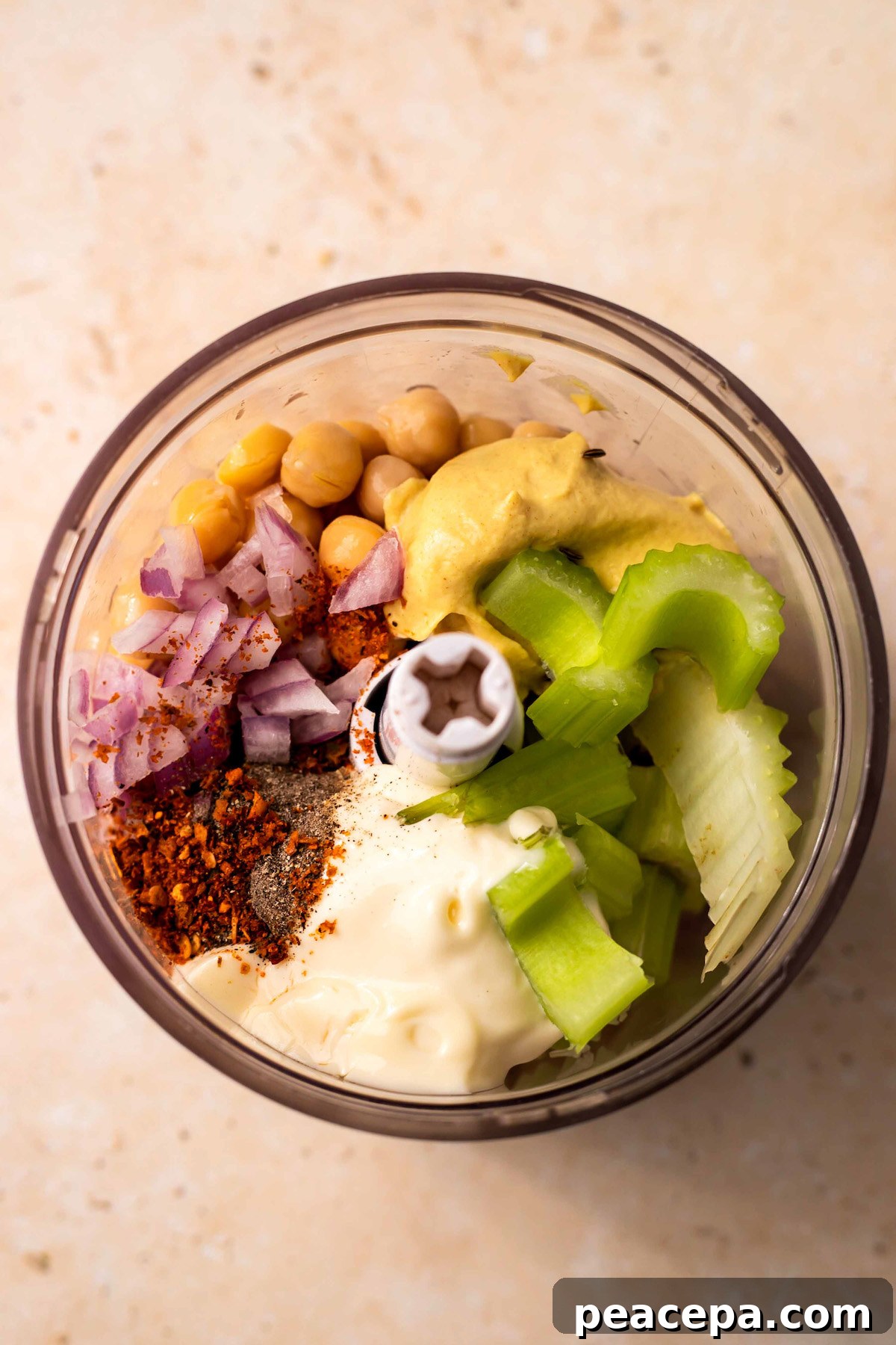 Chickpea, seasonings, and celery in a small food processor bowl.
