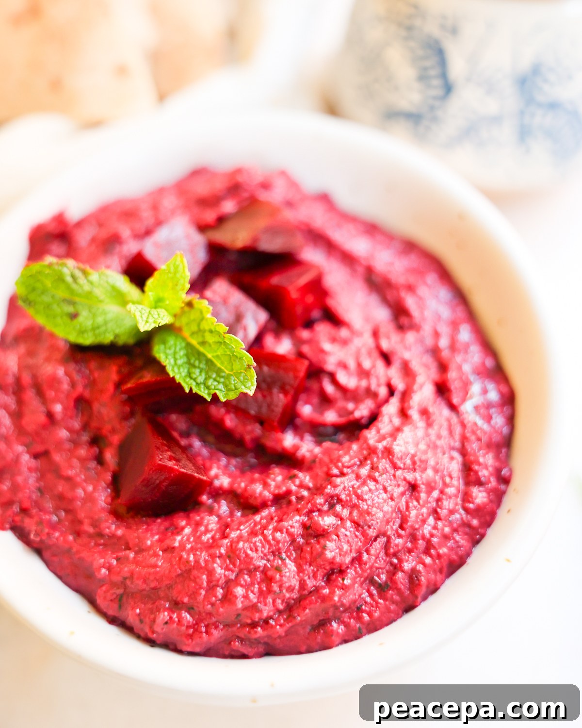 Bowl of beet dip topped with fresh mint.