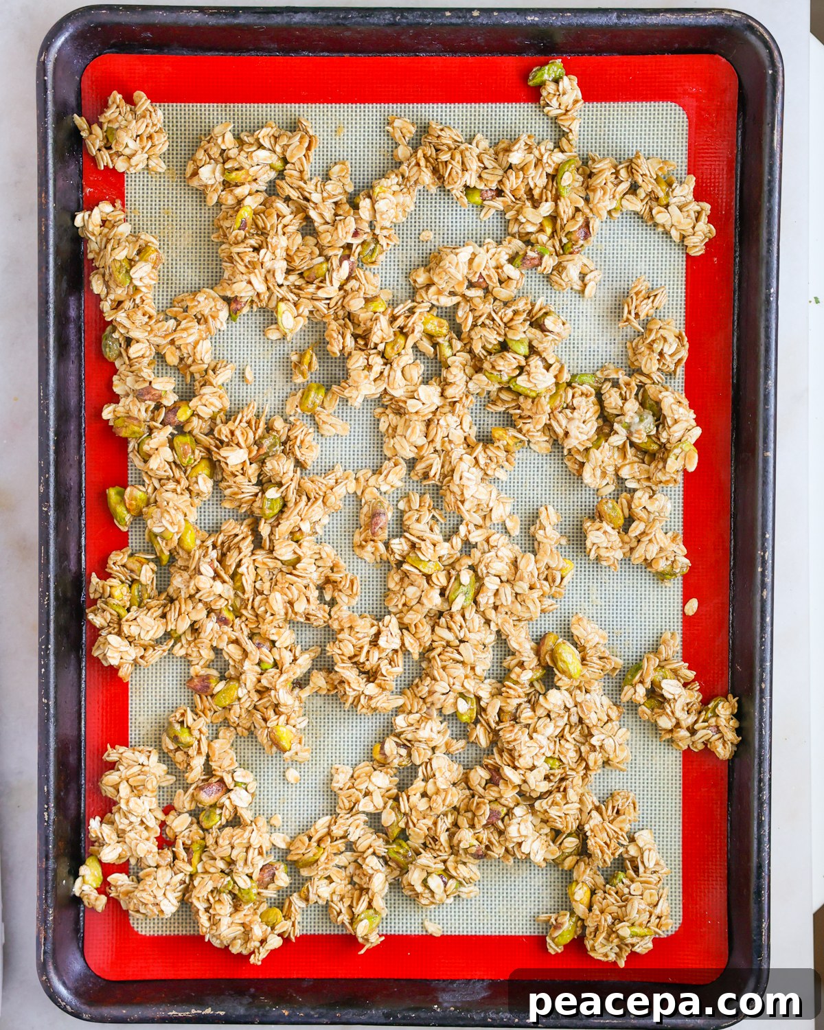 granola spread on baking sheet