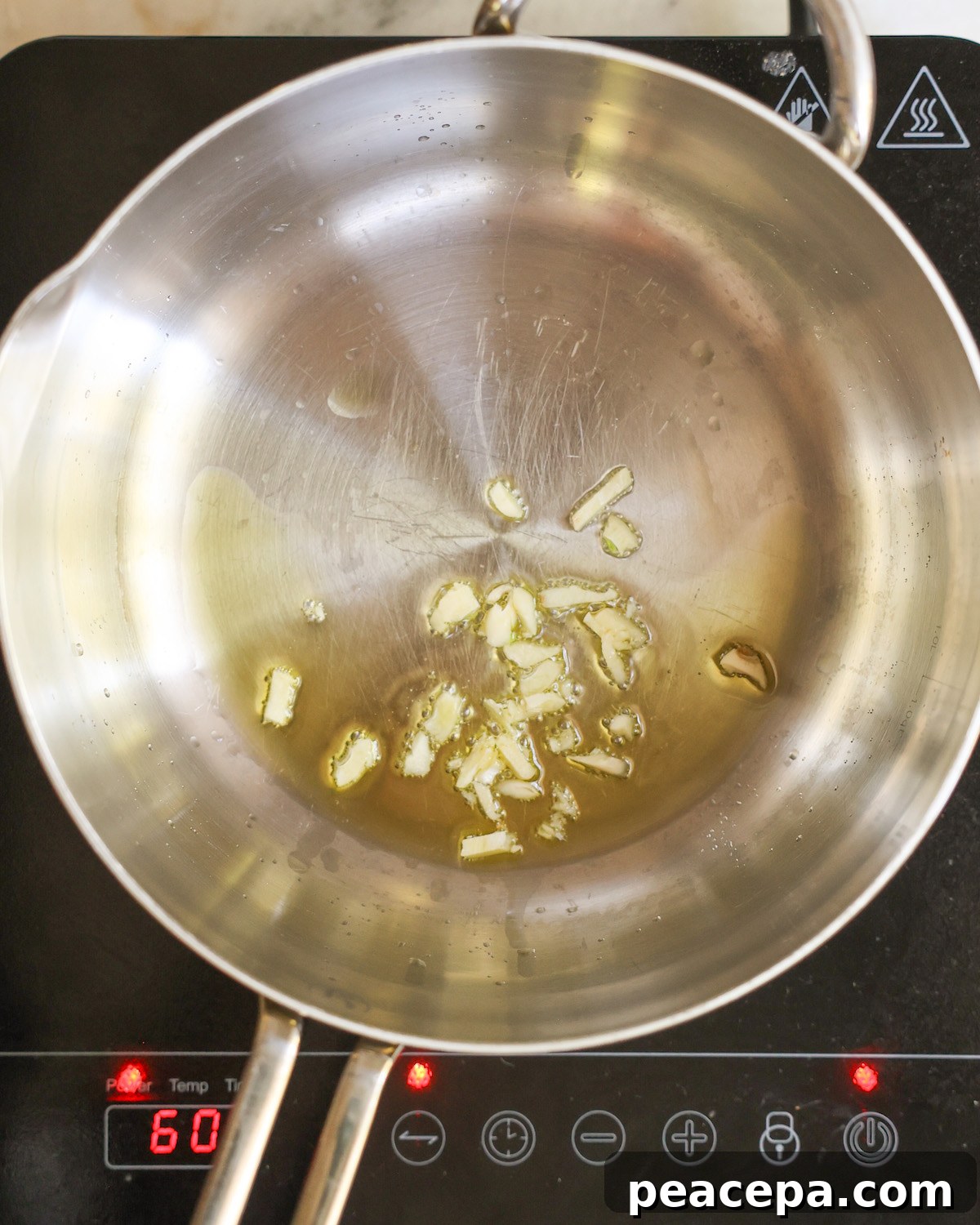 Sauteeing garlic in a saucepan of oil.