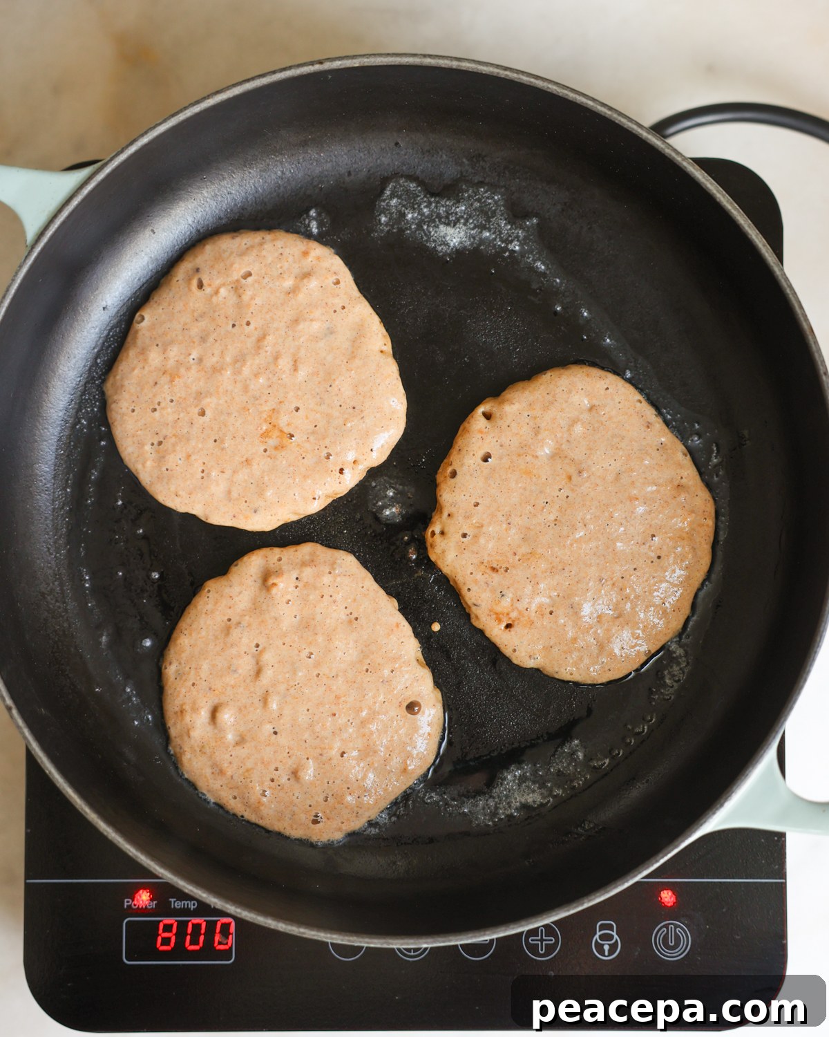 overhead uncooked sides of pancakes in skillet