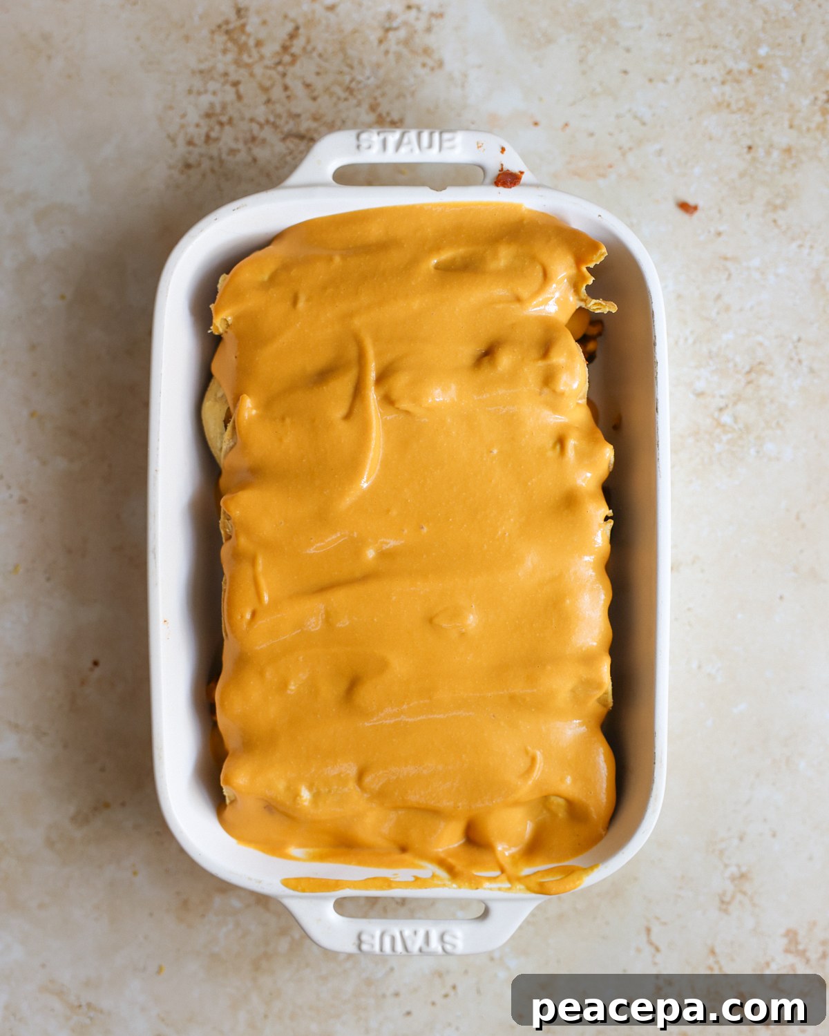 Overhead cheese sauce on enchiladas