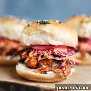 A side shot of mushroom veggie sliders on a wooden cutting board.
