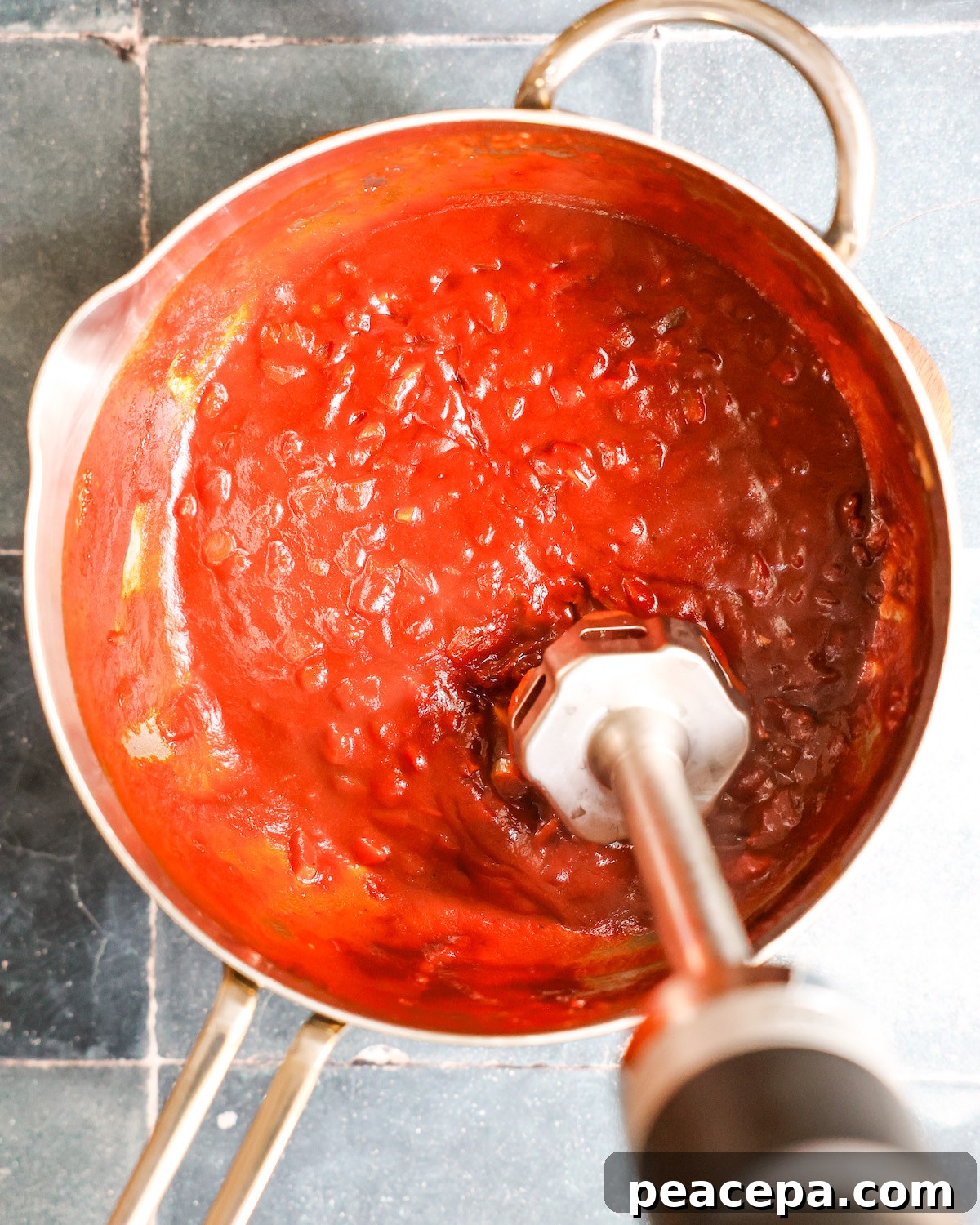 Immersion blender in a pan blending bbq sauce