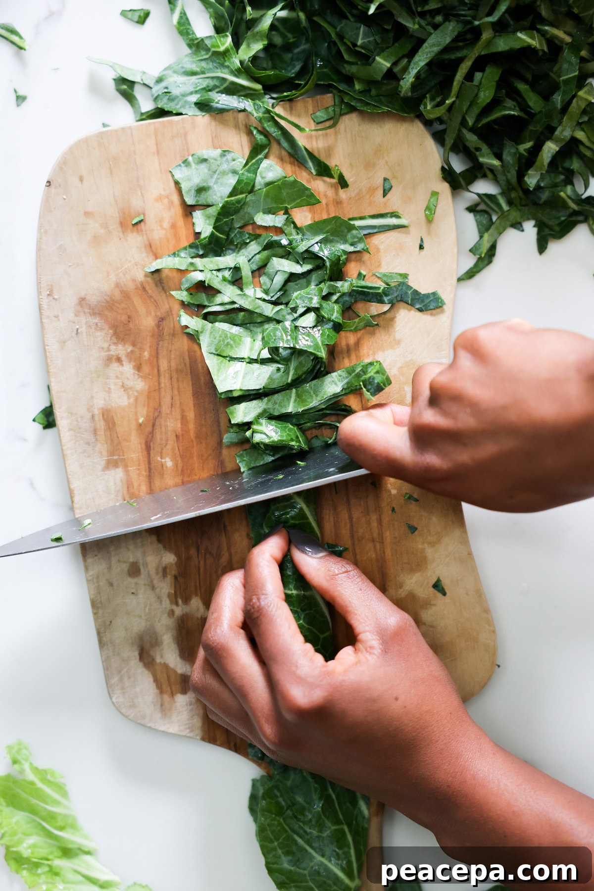 Thinly slicing collard greens in chiffonade style.