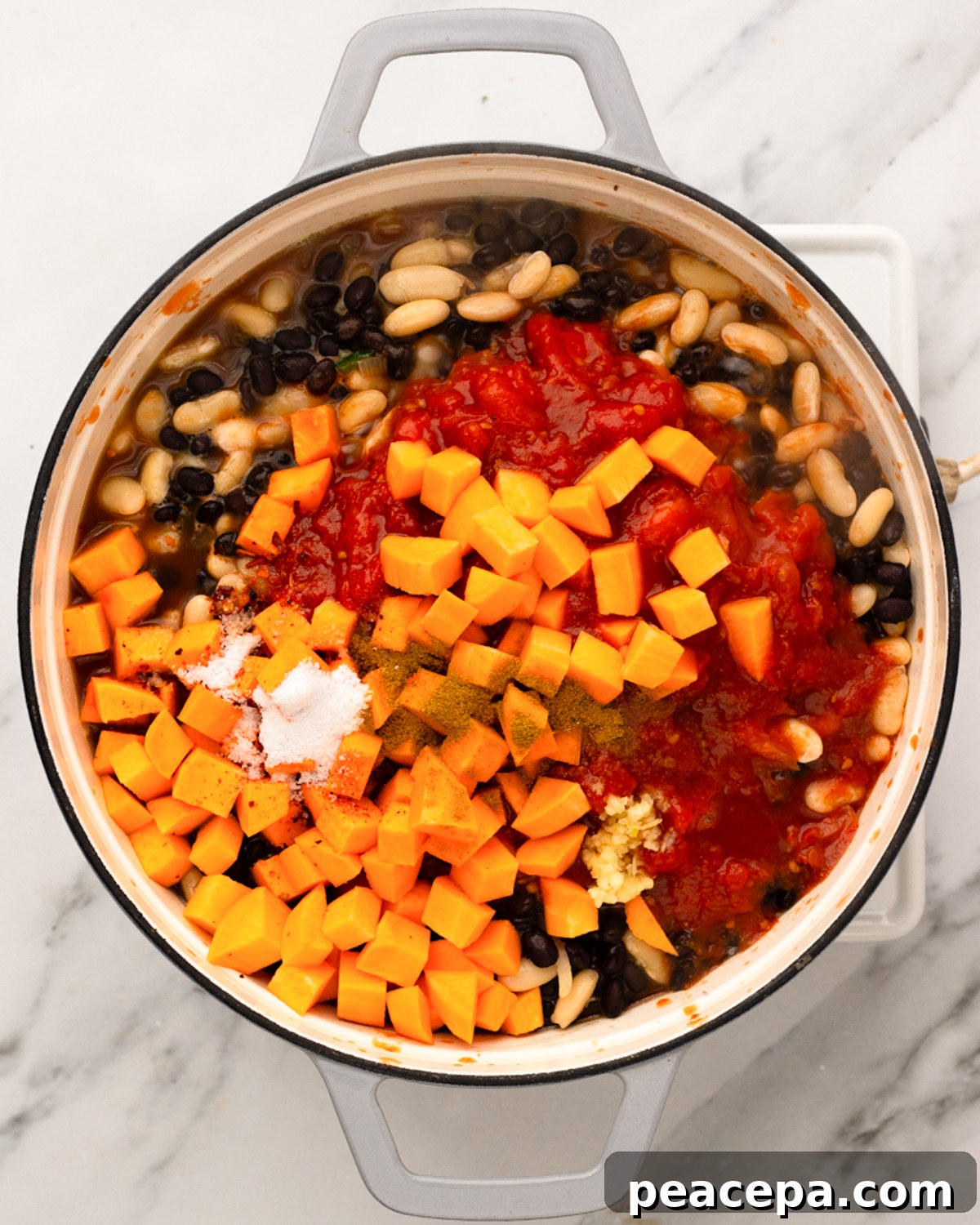 overhead sweet potato and tomatoes added to pot