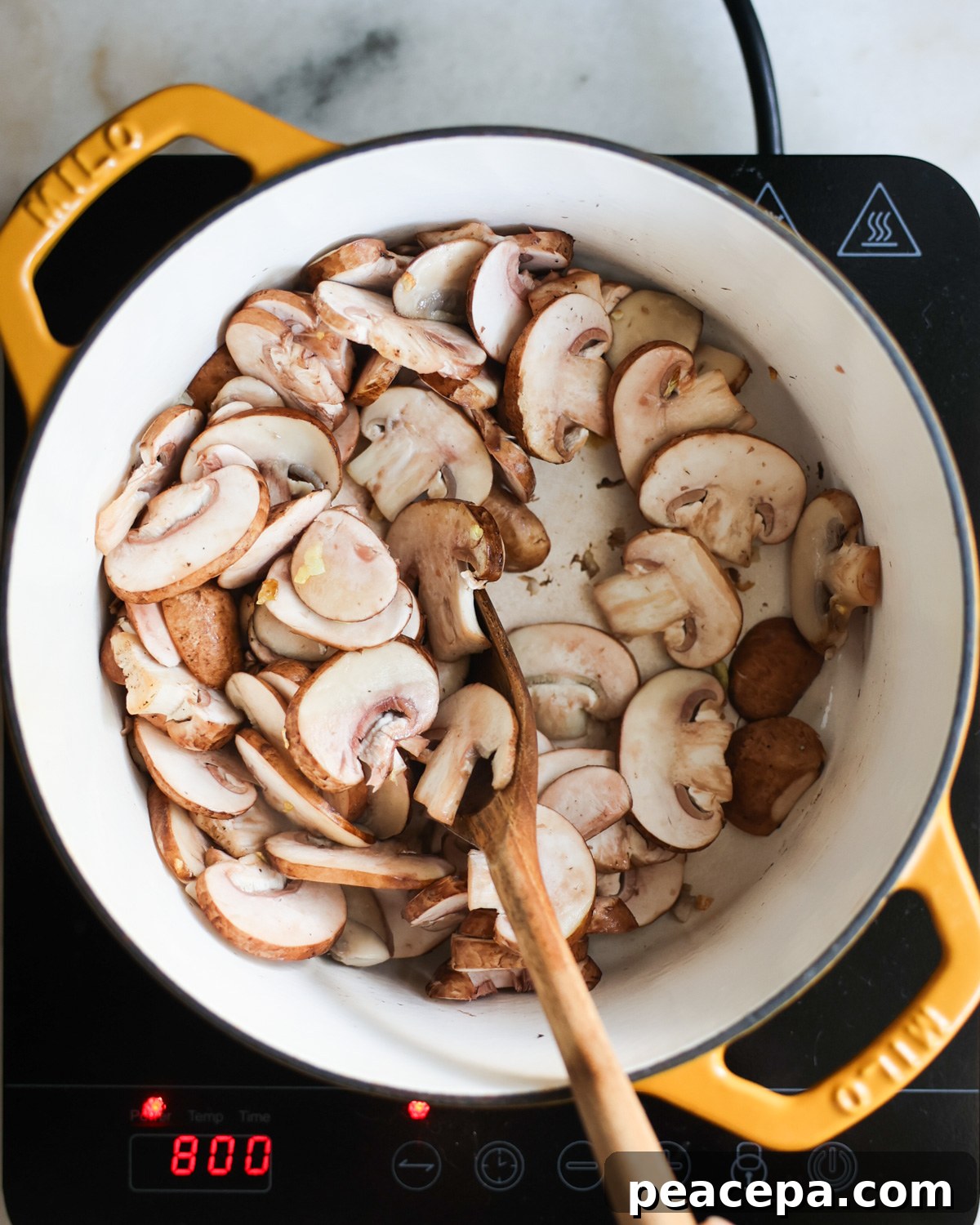 stirring mushrooms in pot