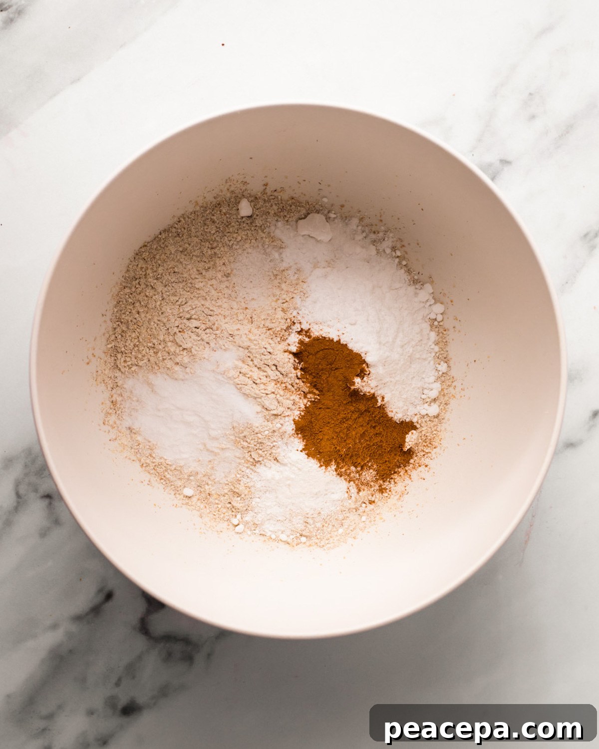 An overhead shot of a bowl of flour, spices, and salt.