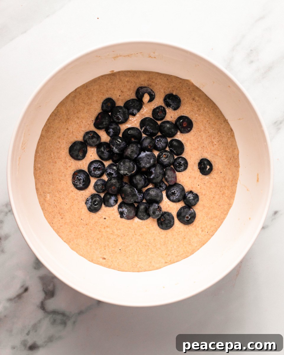 An overhead shot of the vegan pancake batter with bleuberies.