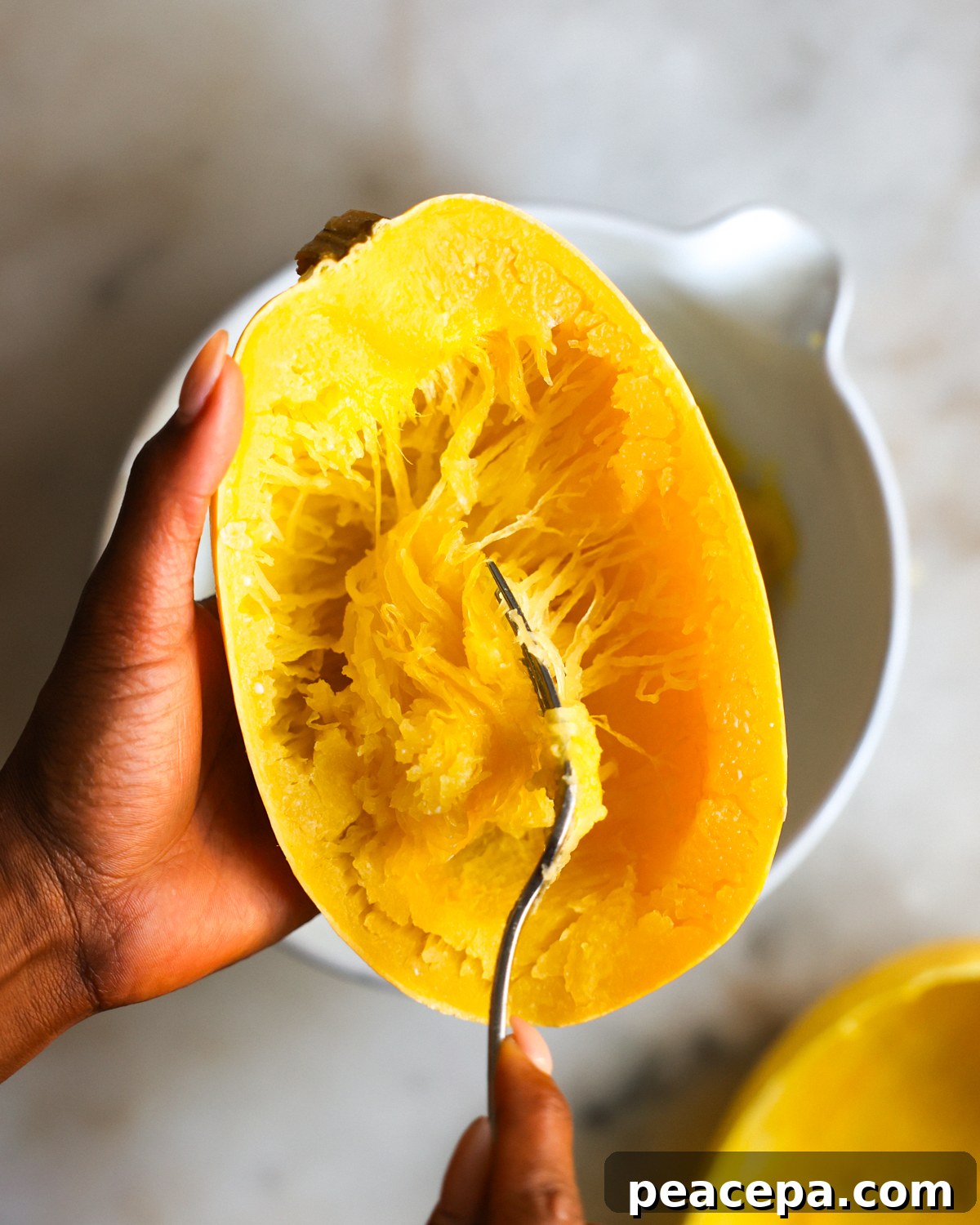 using a fork to scoop spaghetti squash
