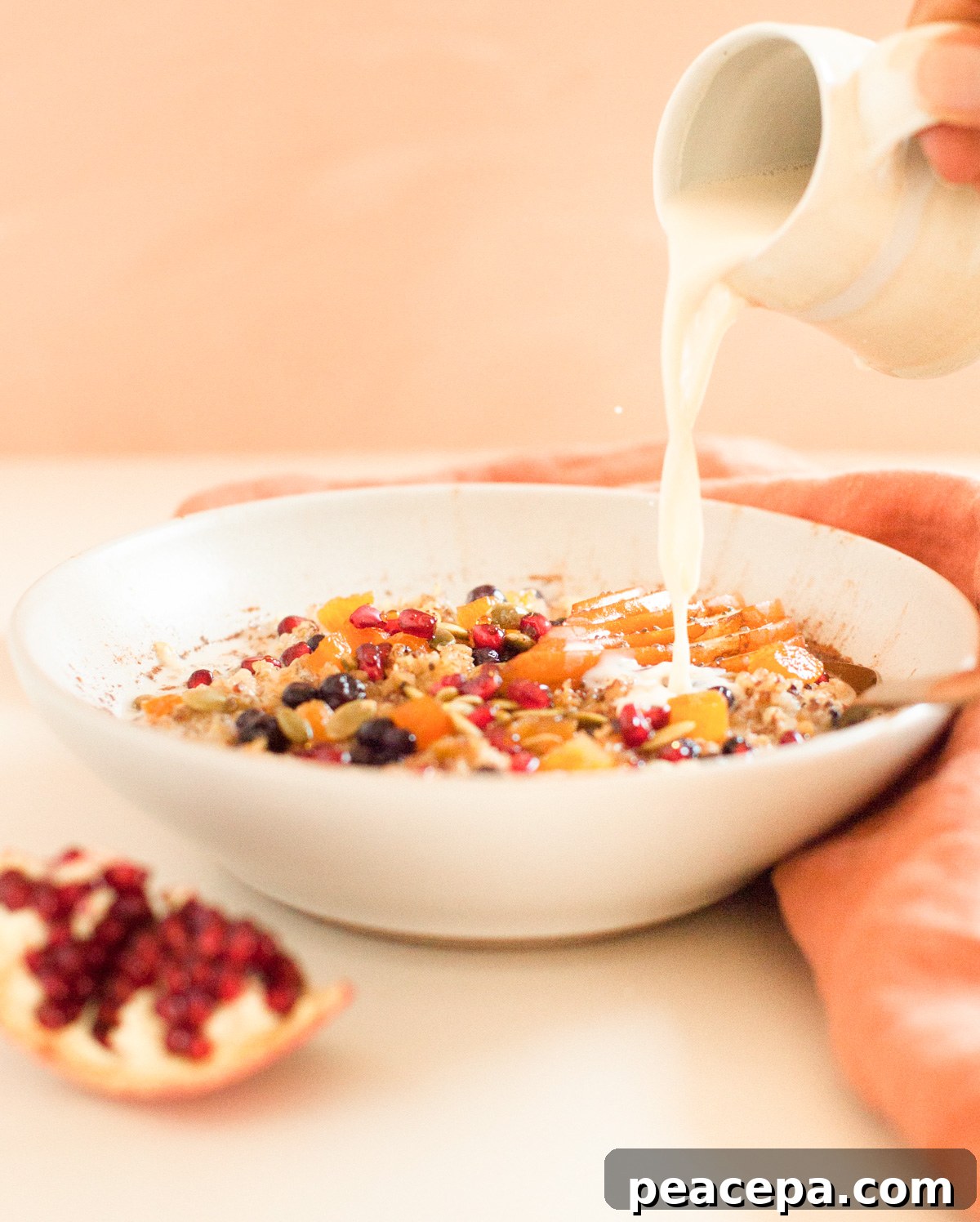 pouring milk over freekeh porridge in bowl