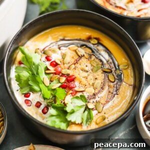Vegan Butternut Squash Soup topped with coconut milk and pomegranates