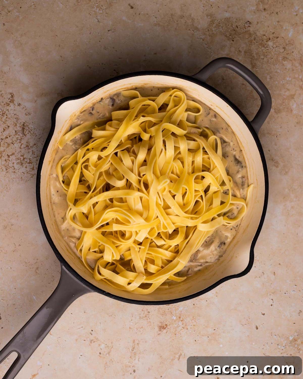 adding pasta to vegan mushroom alfredo sauce